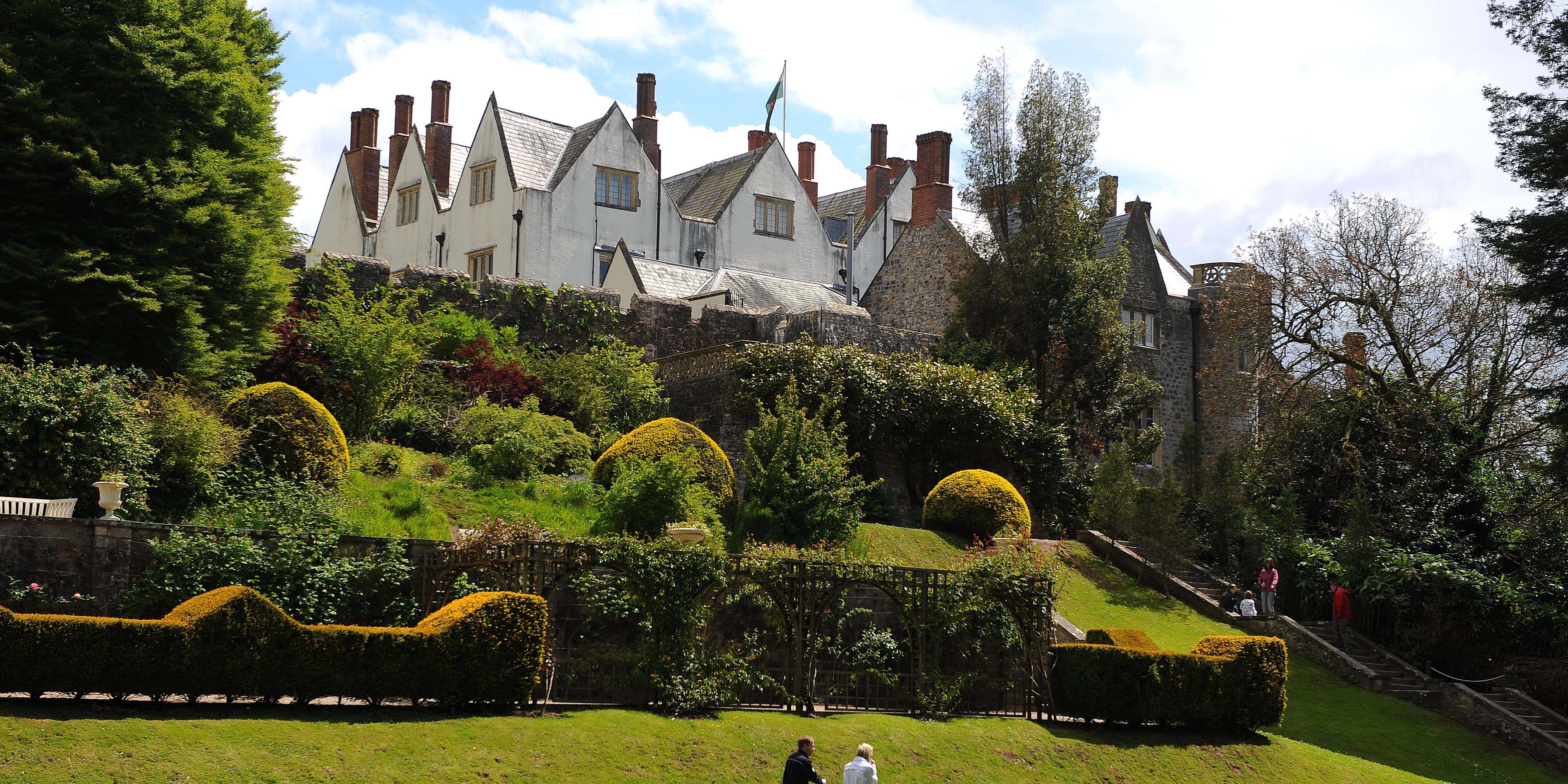 Museum Exteriors© WALES NEWS SERVICE St Fagans Caslte on a green hill with couple below with a pushchair