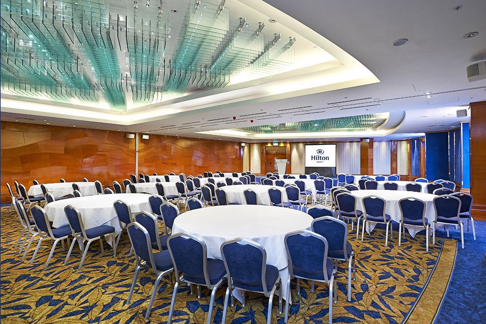 Large ballroom space in the Hilton set up with chairs around circular tables