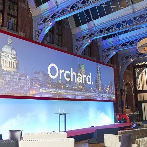 Orchard logo on large screen at venue