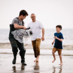 Production filming man and son on the beach