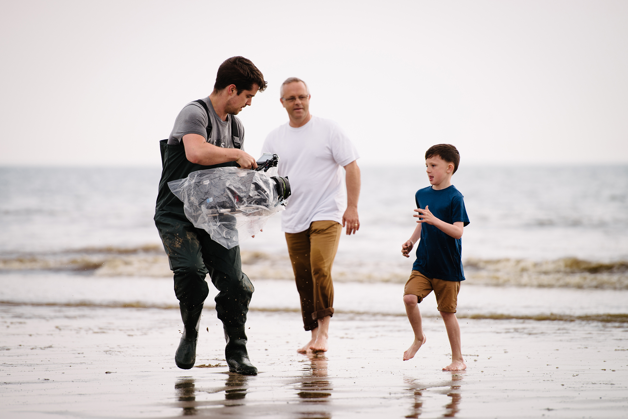 Production filming man and son on the beach