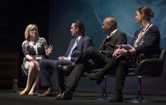 Conference taking place with speakers and guests on stage