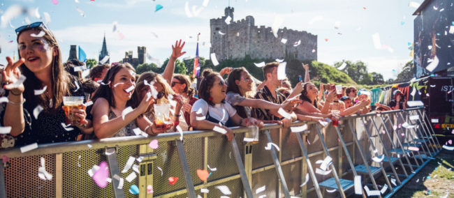 Tafwyl crowd dancing behind barrier with confetti falling